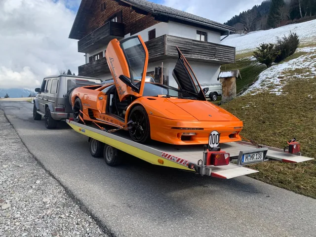 Orangefarbener Lamborghini Diablo auf einem offenen Fahrzeuganhänger