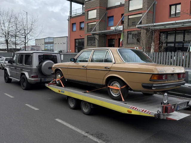 Beigefarbener Mercedes-Benz Oldtimer auf einem offenen Fahrzeuganhänger