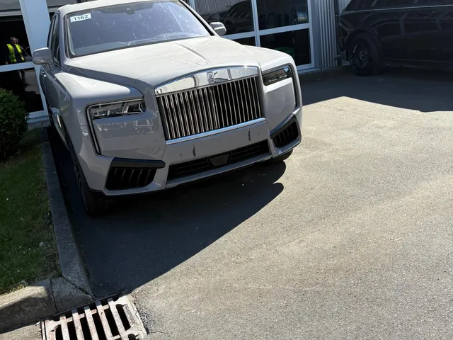 Weißer Rolls-Royce Cullinan vor einem Gebäude