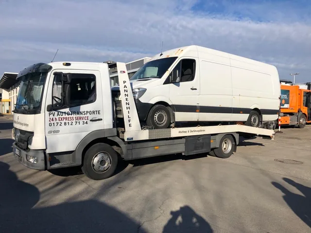 Weißer Transporter auf einem Mercedes Atego Transportfahrzeug