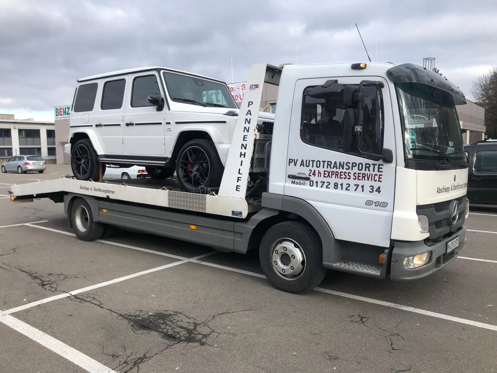 Weiße Mercedes G-Klasse auf einem PV Transportfahrzeug