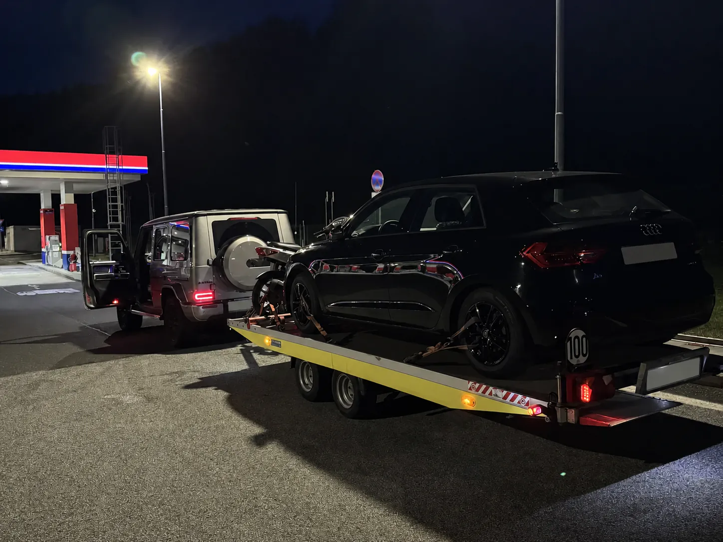 Audi auf einem Fahrzeuganhänger während eines Nachteinsatzes; Kennzeichen unkenntlich gemacht