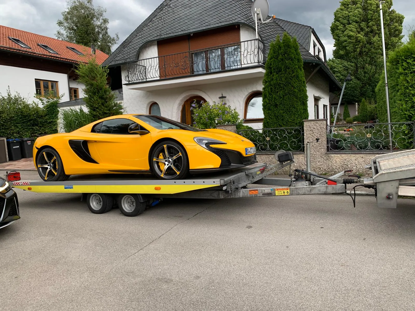 Gelber McLaren 650S Spider auf einem offenen Fahrzeuganhänger