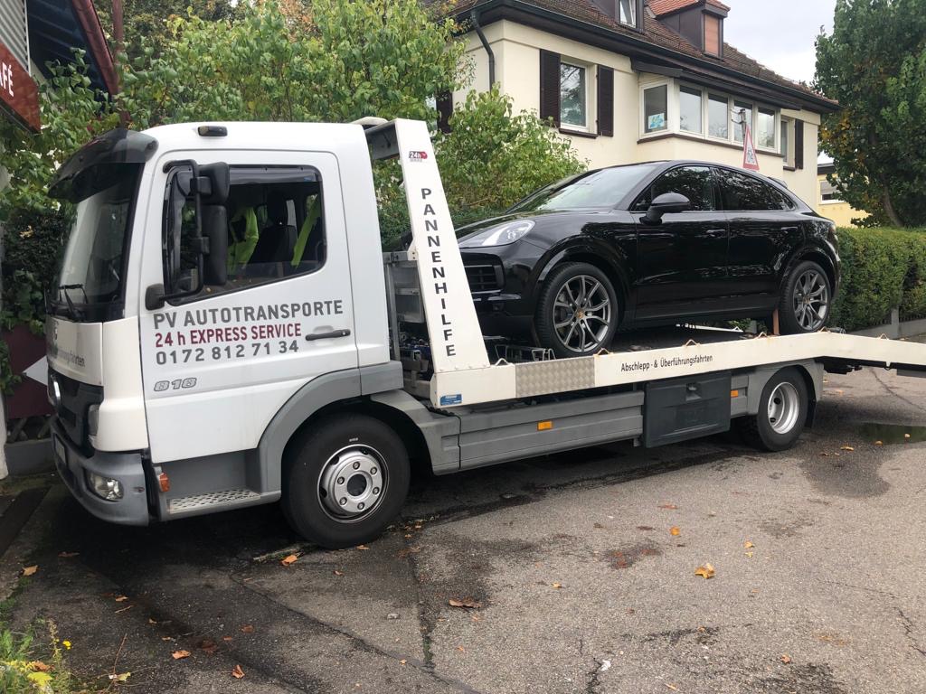 Schwarzer Porsche SUV auf einem PV Transportfahrzeug